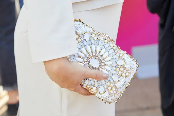 Frau mit weißem Kleid und Tasche mit Dekoration aus Gold und weißen Edelsteinen vor der Modenschau von Luisa beccaria, Mailänder Modewoche im Streetstyle — Stockfoto