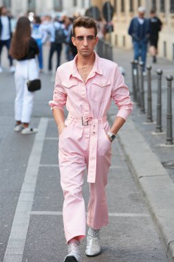 Giorgio Armani moda defilesinden önce pembe tulumlu ve gümüş renkli ayakkabılı bir adam, Milan Moda Haftası tarzı. 