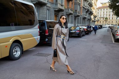 Salvatore Ferragamo moda defilesinden önce altın tokalı bej rengi deri trençkotlu ve kemerli kadın, Milan Moda Haftası tarzı. 