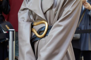 Salvatore Ferragamo defilesinden önce altın tokalı bej renkli deri ceketli ve kemerli kadın, Milan Moda Haftası tarzı. 