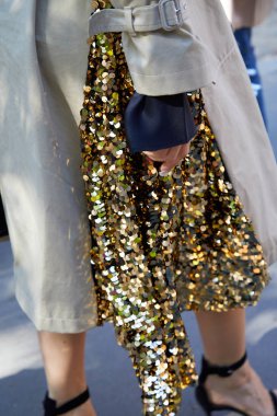 Msgm defilesinden önce altın pullu etekli kadın, Milan Moda Haftası tarzı. 