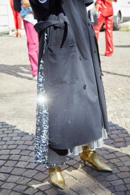 Msgm moda defilesinden önce gümüş pullu etekli ve altın metalik çizmeli kadın, Milan Moda Haftası tarzı. 