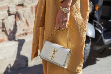 Altın elbiseli kadın, gümüş Yves Saint Laurent çantası ve Rolex saati Ermanno Scervino moda defilesinden önce, Milan Moda Haftası tarzı 