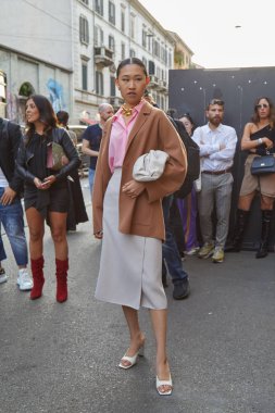 Agnona moda defilesinden önce pembe gömlekli ve bej ceketli kadın, Milan Moda Haftası tarzı. 