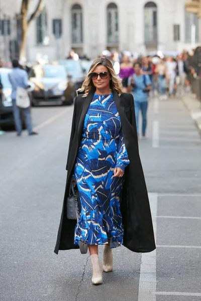 Mulher com tons azuis vestido e casaco preto longo antes Giorgio Armani desfile de moda, Milan Fashion Week street style — Fotografia de Stock