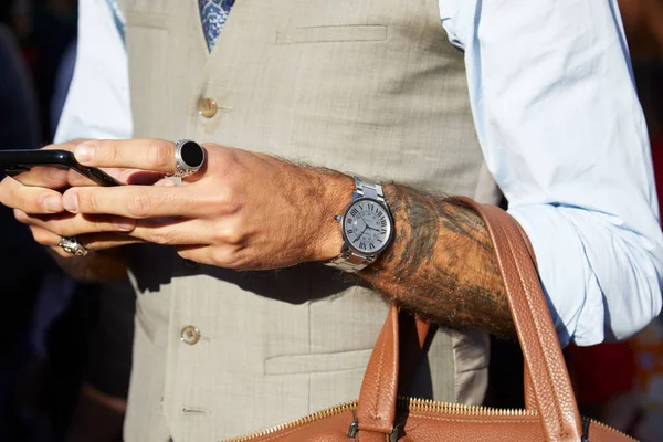 Man with Cartier watch looking at smartphone before Salvatore Ferragamo fashion show, Milan Fashion Week street style — стокове фото