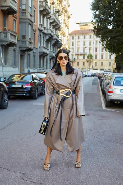 Mujer con gabardina de cuero beige y cinturón con hebilla dorada antes del desfile de moda Salvatore Ferragamo, Milan Fashion Week street style — Foto de Stock