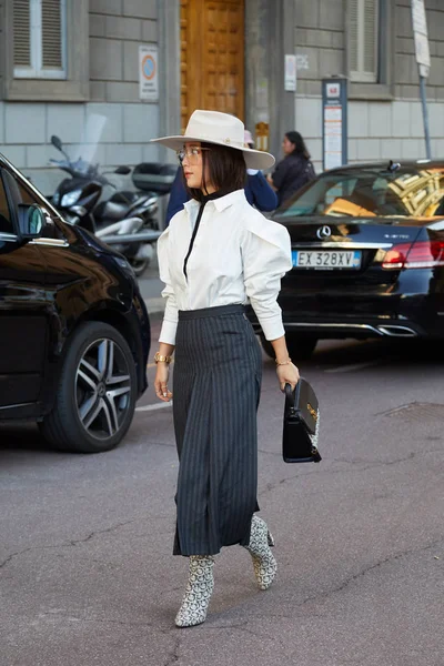 Mujer con sombrero blanco, camisa y botas Ferragamo caminando antes del desfile de moda Salvatore Ferragamo, Milan Fashion Week street style —  Fotos de Stock