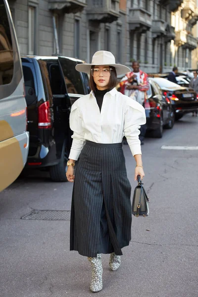 Beyaz şapkalı, gömlekli ve Ferragamo botlu kadın Salvatore Ferragamo defilesinden önce yürüyor, Milan Moda Haftası tarzı. — Stok fotoğraf