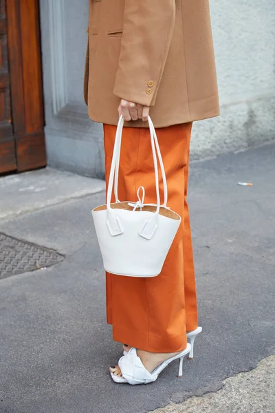 Mujer con bolsa de cuero blanco y pantalones naranjas antes del desfile de moda Salvatore Ferragamo, Milan Fashion Week street style — Foto de Stock