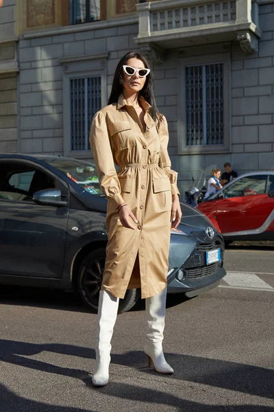 Femme avec robe en cuir beige et bottes blanches avant le défilé Salvatore Ferragamo, Milan Fashion Week street style — Photo