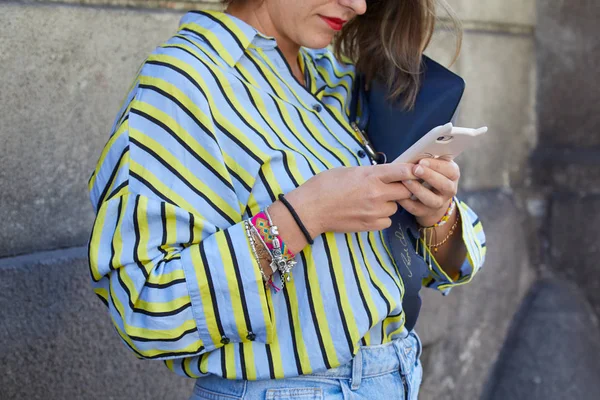 Mujer con camisa azul, amarilla y negra mirando el smartphone antes del desfile de moda Ermanno Scervino, Milan Fashion Week street style — Foto de Stock