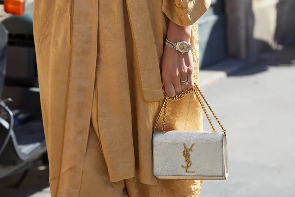 Kvinne med gyllen kjole, sølvfarget Yves Saint Laurent veske og Rolex watch før Ermanno Scervino moteshow, Milano Fashion Week street style – stockfoto