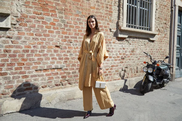 Mujer con vestido dorado y bolso Yves Saint Laurent antes del desfile de moda Ermanno Scervino, Milan Fashion Week street style — Foto de Stock