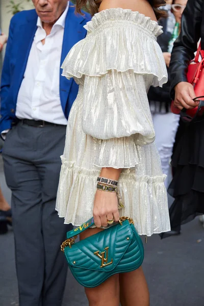 Mujer con bolso Louis Vuitton de cuero verde y vestido de plata blanco antes del desfile de moda Giorgio Armani, Milan Fashion Week street style — Foto de Stock