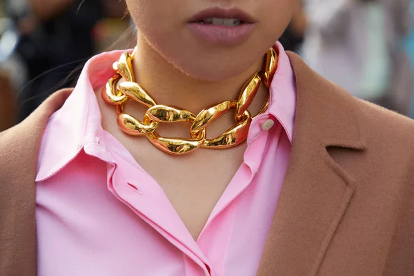Женщина с золотым ожерельем и розовой рубашкой перед показом мод в стиле Недели моды в Милане — стоковое фото