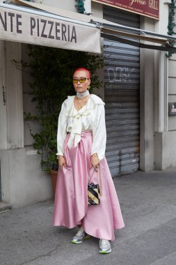 Fila defilesinden önce pembe etekli, beyaz ipek gömlekli ve Gucci çantalı kadın, Milan Moda Haftası tarzı. 