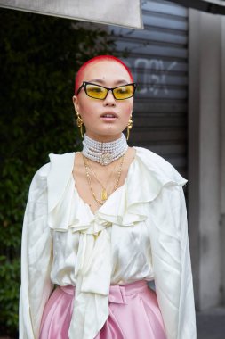 Beyaz ipek gömlekli, incili ve altın kolyeli kadın. Fila moda defilesinden önce, Milan Moda Haftası tarzı. 