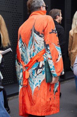 Gucci moda defilesinden önce mavi ve beyaz desenli turuncu trençkot giyen adam, Milan Moda Haftası tarzı. 
