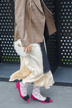 Gucci moda defilesinden önce pembe ayakkabılı, Gucci çoraplı ve çantalı kadın, Milan Moda Haftası tarzı. 
