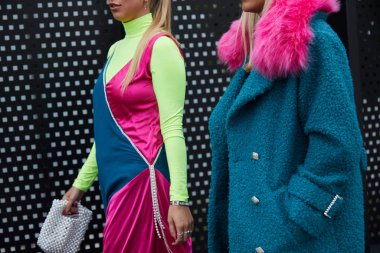 Gucci moda defilesinden önce mavi kürklü ve sarı yeşil elbiseli kadınlar, Milan Moda Haftası tarzı. 
