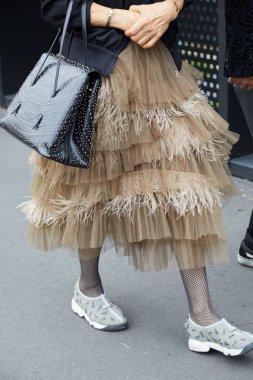 Gucci defilesinden önce tüylü bej renkli şifon etekli kadın, Milan Moda Haftası tarzı. 