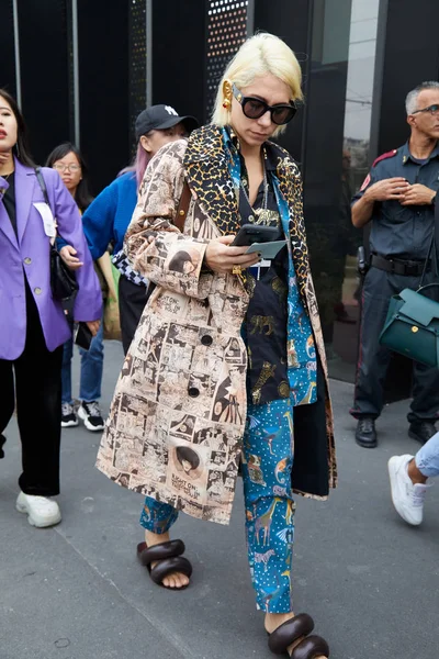 Gucci çantalı ve çizgi roman tasarımlı kahverengi ceketli bir kadın Gucci moda defilesinden önce akıllı telefona bakıyor, Milan Moda Haftası tarzı. — Stok fotoğraf