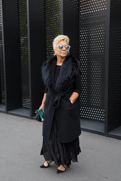 Mujer con chaqueta larga y negra con cuello de piel antes del desfile de moda de Gucci, Milan Fashion Week street style —  Fotos de Stock