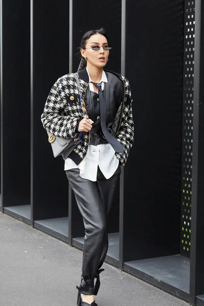 Женщина в черных кожаных брюках и черно-белой куртке из хаундстука перед показом мод Gucci в стиле Недели моды в Милане — стоковое фото