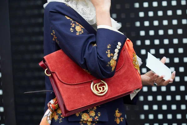 Mulher com saco de camurça Gucci vermelho com logotipo dourado e casaco azul com design floral antes do desfile de moda Gucci, estilo de rua Milan Fashion Week — Fotografia de Stock