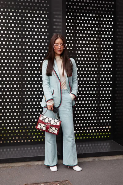 Femme avec veste et pantalon bleu pâle et sac Gucci rouge avant le défilé Gucci, Milan Fashion Week street style — Photo