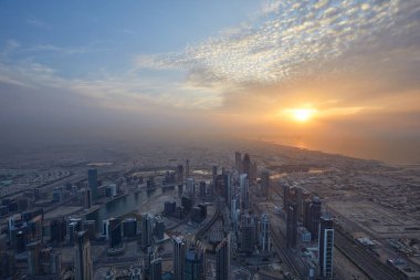 Dubai şehrinin yüksek açılı manzarası Burj Halife 'den gün batımında gökdelenlerle birlikte görülüyor.