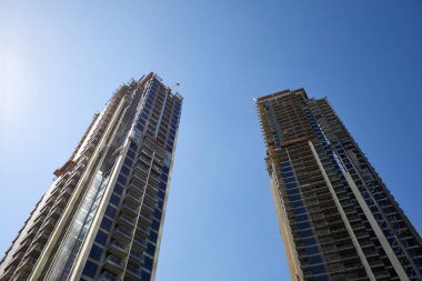 İnşaat halindeki gökdelenler, güneşli bir günde alçak açı, Dubai 'de açık mavi gökyüzü.