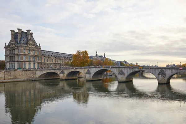 Louvren slott och bro med Seine flodutsikt i en höstdag i Paris, Frankrike — Stockfoto