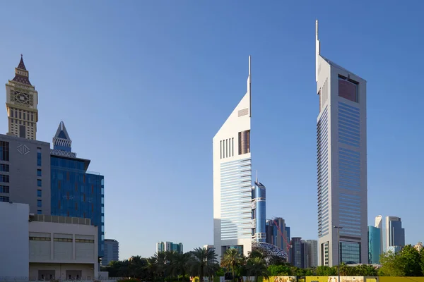 Dubai finans bölgesi, modern gökdelenler ve güneşli bir günde palmiye ağaçları, mavi gökyüzü — Stok fotoğraf
