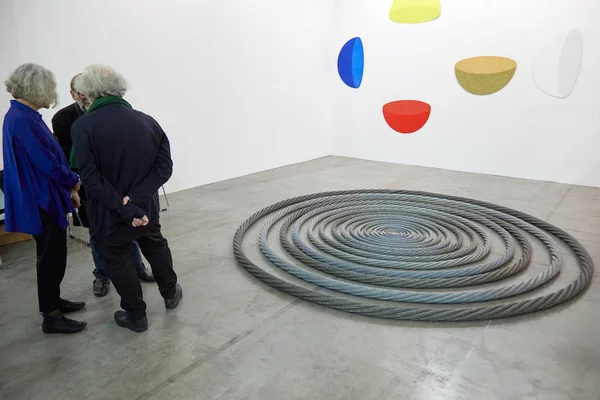 Pessoas conversando e obras de arte com círculos durante a abertura da feira de arte contemporânea Artissima no palácio Oval Lingotto em Turim, Itália — Fotografia de Stock