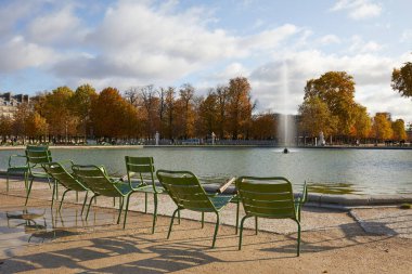 Paris 'te güneşli bir sonbahar gününde boş metal sandalyeli ve çeşmeli Tuileries bahçesi