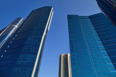 Modern gökdelenler, güneşli bir günde alçak açı, Dubai 'de açık mavi gökyüzü