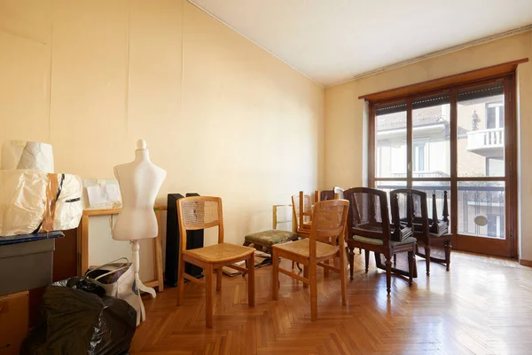 Room with chairs, boxes and a tailor dummy before moving house — Stock Photo, Image