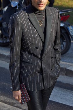 Emporio Armani moda defilesinden önce siyah ceketli, beyaz yakalı ve siyah balıkçı yakalı bir adam, Milan Moda Haftası tarzı. 