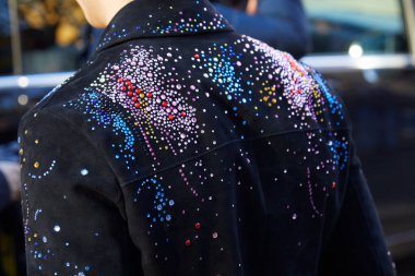 Emporio Armani defilesinden önce renkli boncuklu ve mücevherli siyah ceketli adam, Milan Moda Haftası tarzı. 