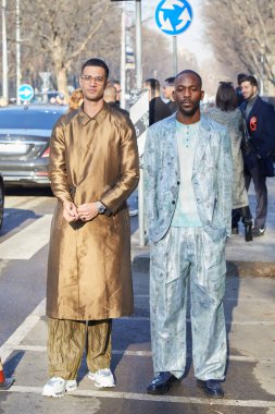 Emporio Armani moda defilesinden önce bronz ceketli, açık mavi ceketli ve pantolonlu adamlar, Milan Moda Haftası tarzı. 