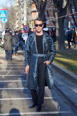 Emporio Armani moda defilesinden önce mavi leopar desenli parlak ceketli bir adam, Milan Moda Haftası tarzı. 