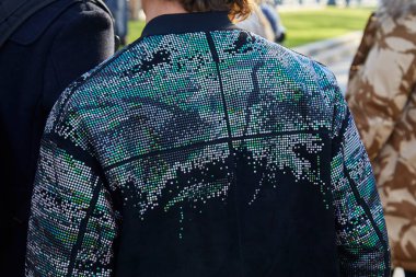 Emporio Armani moda defilesinden önce yeşil, gümüş ve gri madalyalı bir adam, Milan Moda Haftası tarzı. 