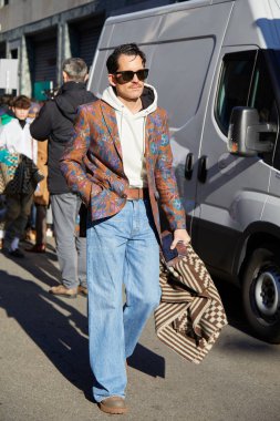 Kahverengi ceketli, çiçek desenli ve kot pantolonlu bir adam Etro moda defilesinden önce, Milan Moda Haftası tarzı 