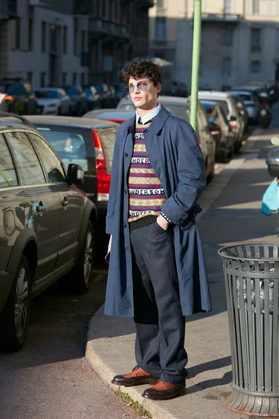 Man with blue coat and sweater in red, blue, green, and beige colors before Salvatore Ferragamo fashion show, Milan Fashion Week street style — Stock Photo, Image