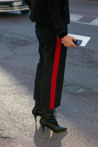 Mujer con pantalones negros con franja roja antes del desfile de moda Salvatore Ferragamo, Milan Fashion Week street style — Foto de Stock