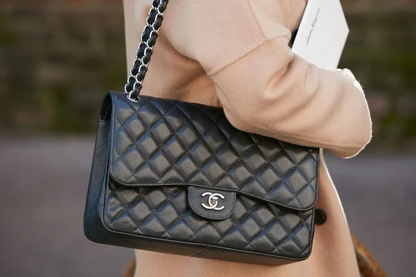 Kobieta z czarną skórzaną torebką Chanel i beżową kurtką przed pokazem mody Salvatore Ferragamo, Milan Fashion Week street style — Zdjęcie stockowe