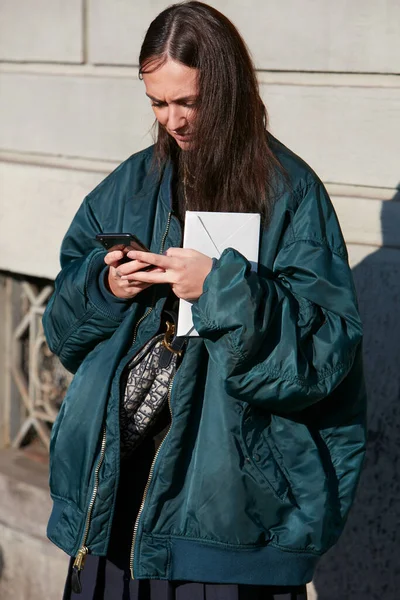 Nő kék bombázó kabát néz okostelefon előtt Salvatore Ferragamo divatbemutató, Milánó Fashion Week utcai stílus — Stock Fotó