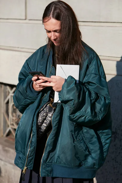 Mulher com jaqueta azul bomber olhando para o smartphone antes Salvatore Ferragamo desfile de moda, Milan Fashion Week street style — Fotografia de Stock